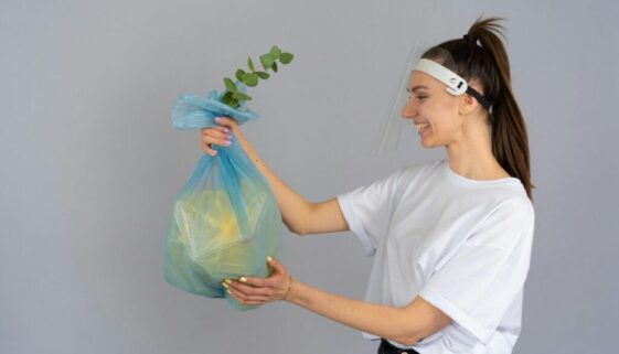 A plastic garbage bag with a plant coming out of it