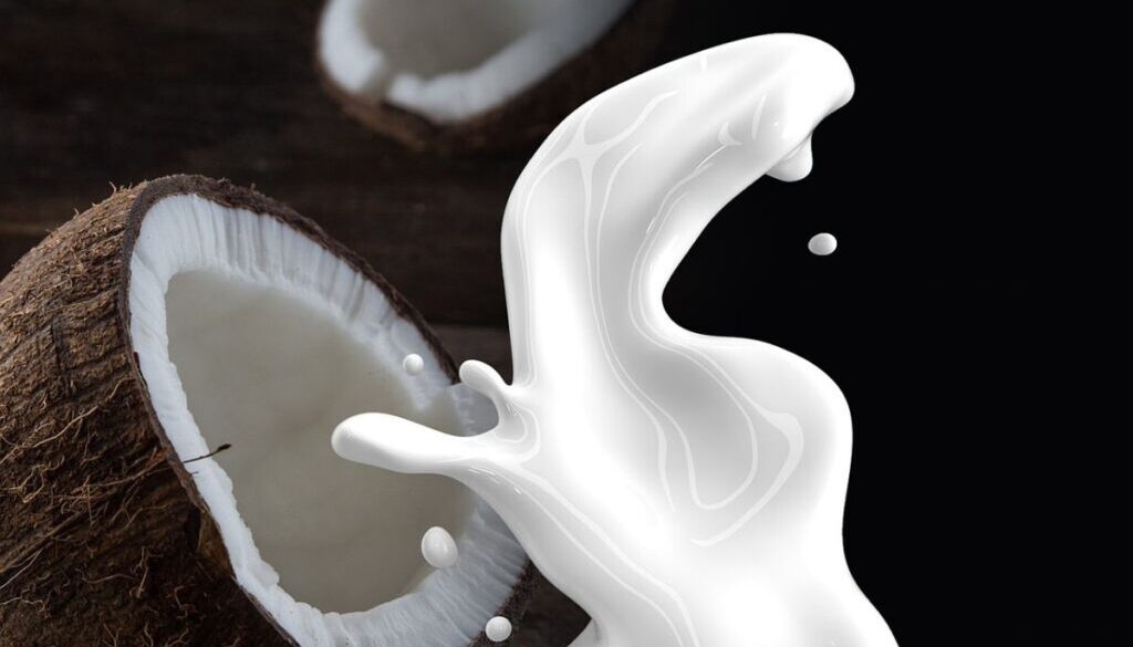 Coconut with milk splashing front of it.