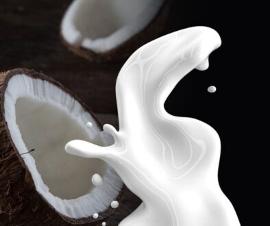 Coconut with milk splashing front of it.