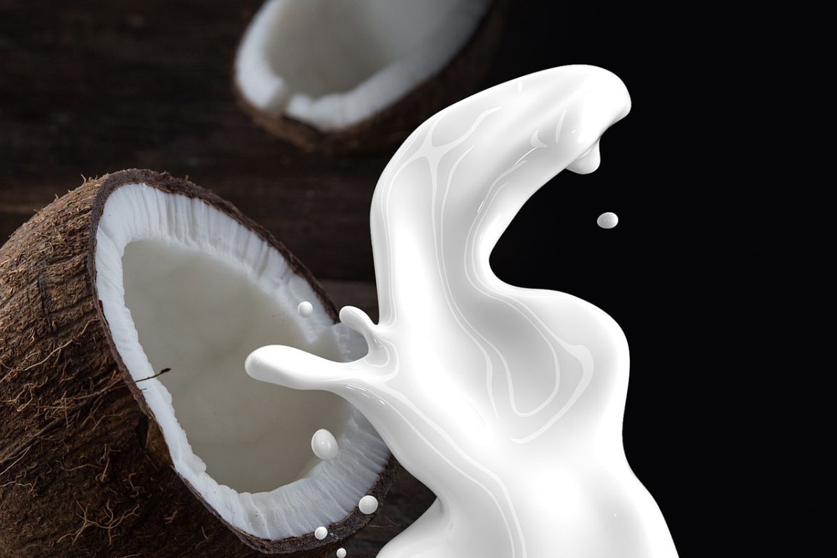 Coconut with milk splashing front of it.